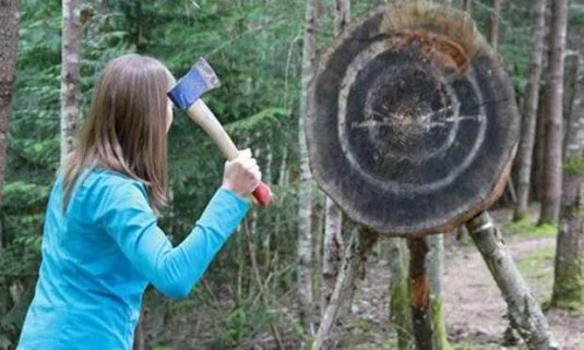 Woman throwing an axe at a target at her friends hen do